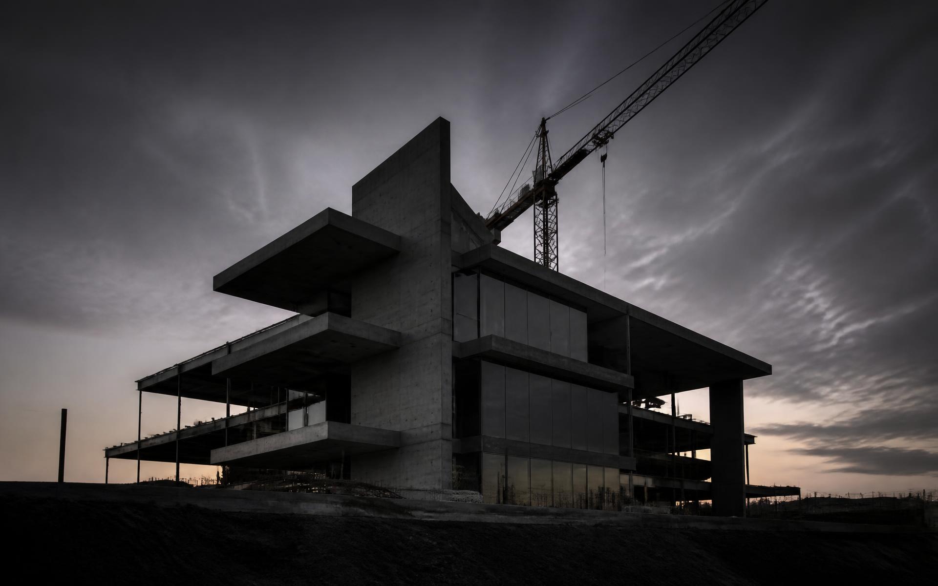 Concrete and steel building under construction at dusk